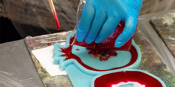the art process of pouring epoxy resin into a wooden toy. techno